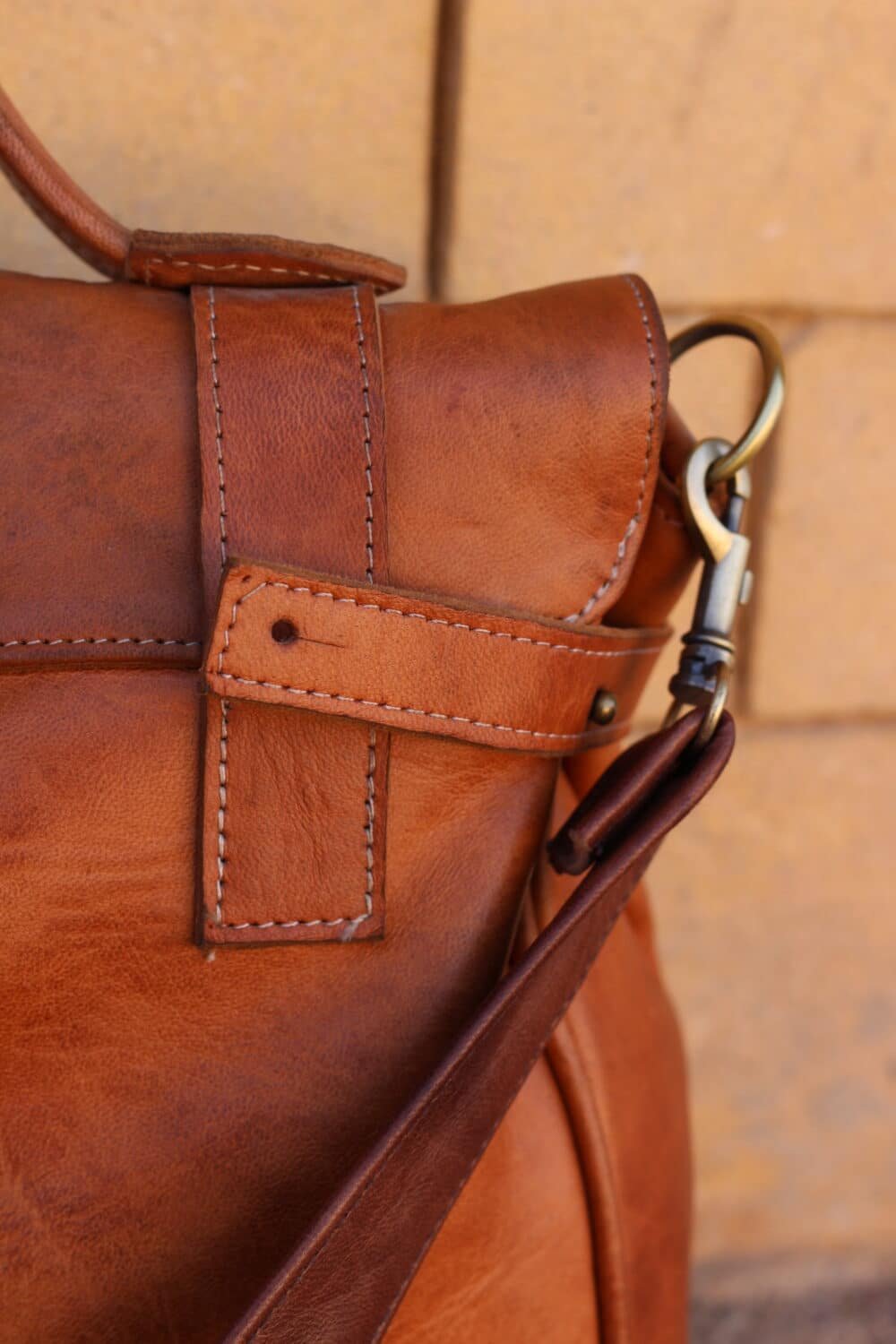 Leather Shoulder Bag displayed with everyday essentials like a phone and keys.