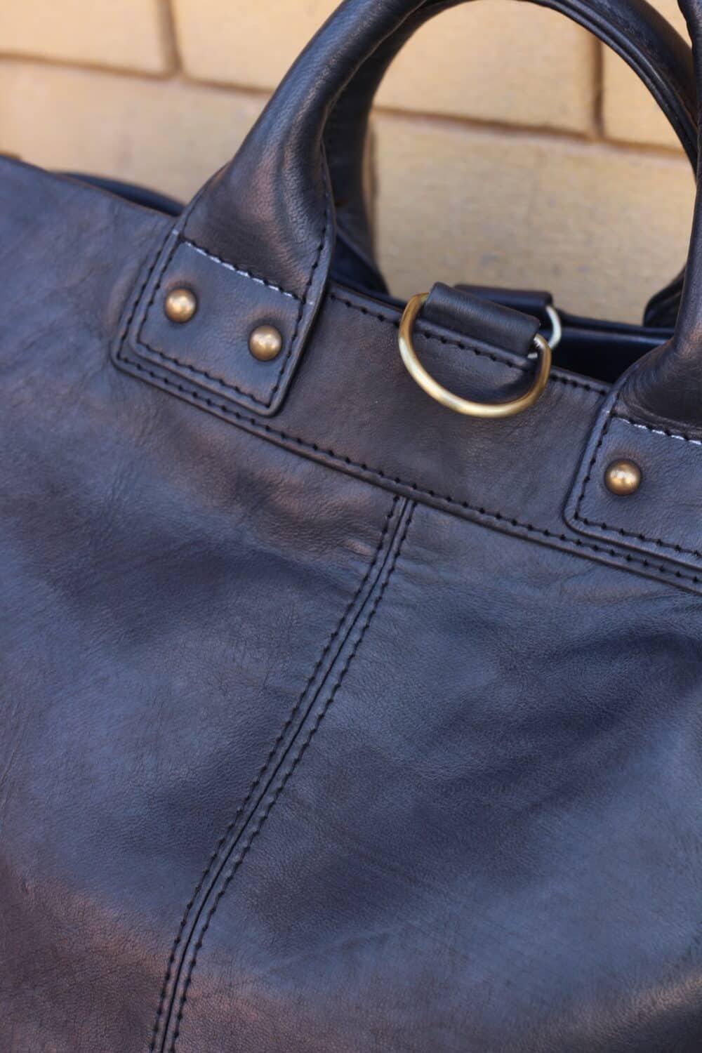 Close-up of stitching details on the Leather Messenger Bag.