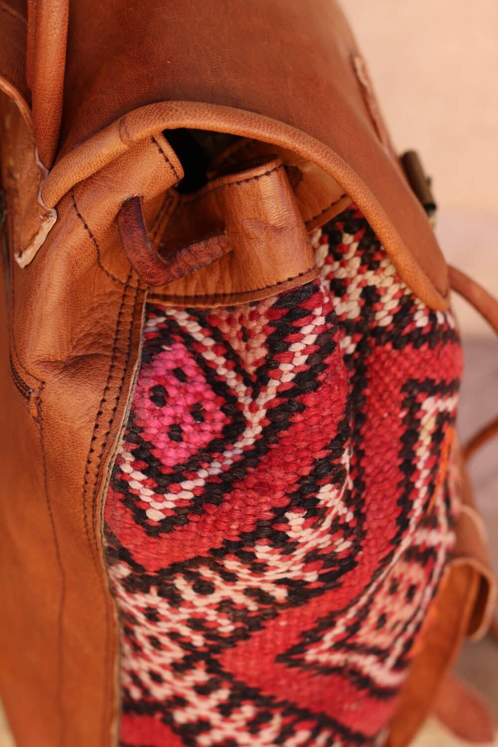 Side view of unique leather backpack purse with exterior pocket.