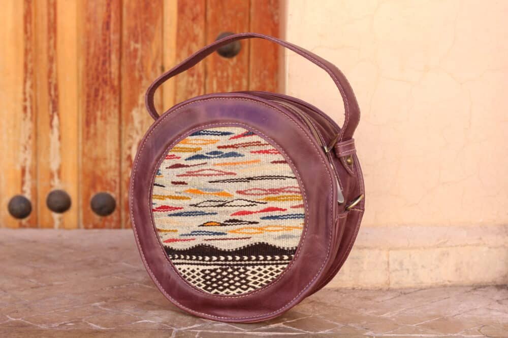 Moroccan round bag leather with colorful traditional patterns.