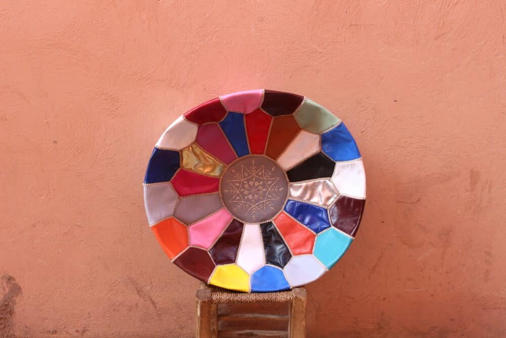 A Multicolor Moroccan Leather Pouf showcasing a mosaic-style design, handcrafted with genuine leather.