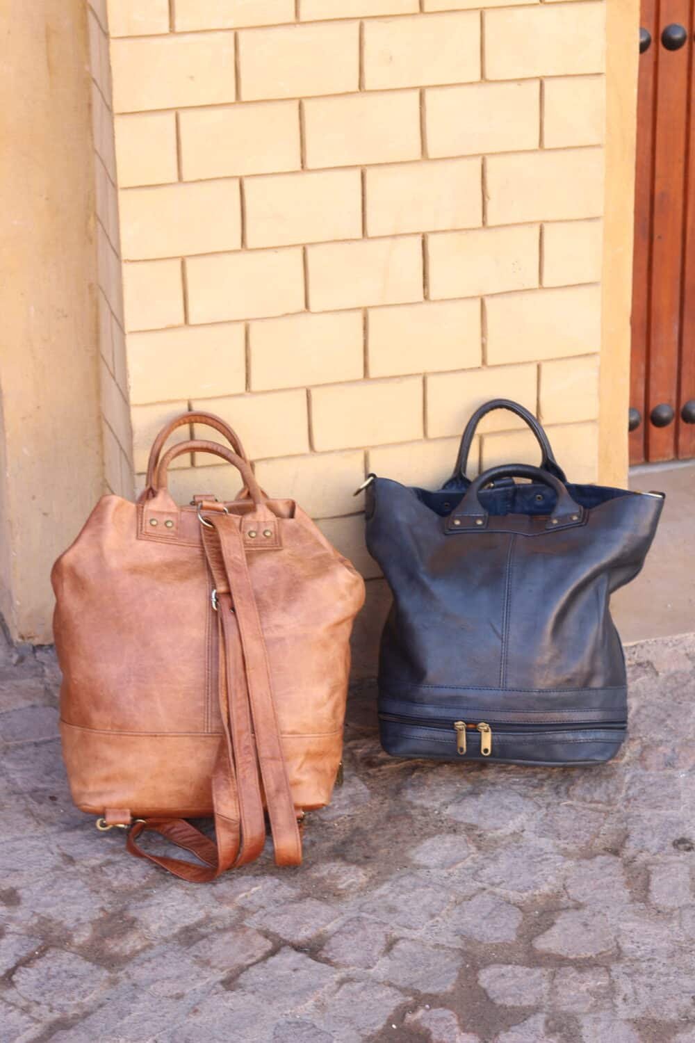 Man carrying a Leather Messenger Bag while walking through an office hallway.