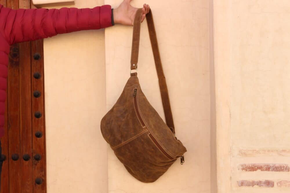 Premium Leather Sling Bag with adjustable straps, compact design, and spacious interior.