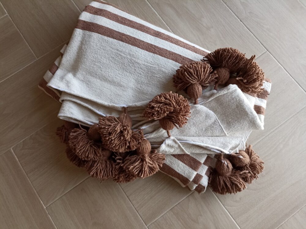 Handcrafted Moroccan Striped Pom-Pom Blanket in earthy tones