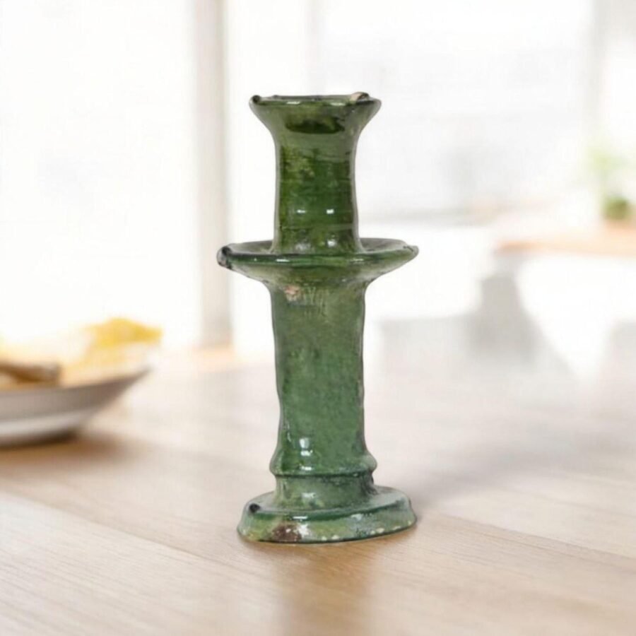 Close-up of a handcrafted ceramic candle holder with a lit candle