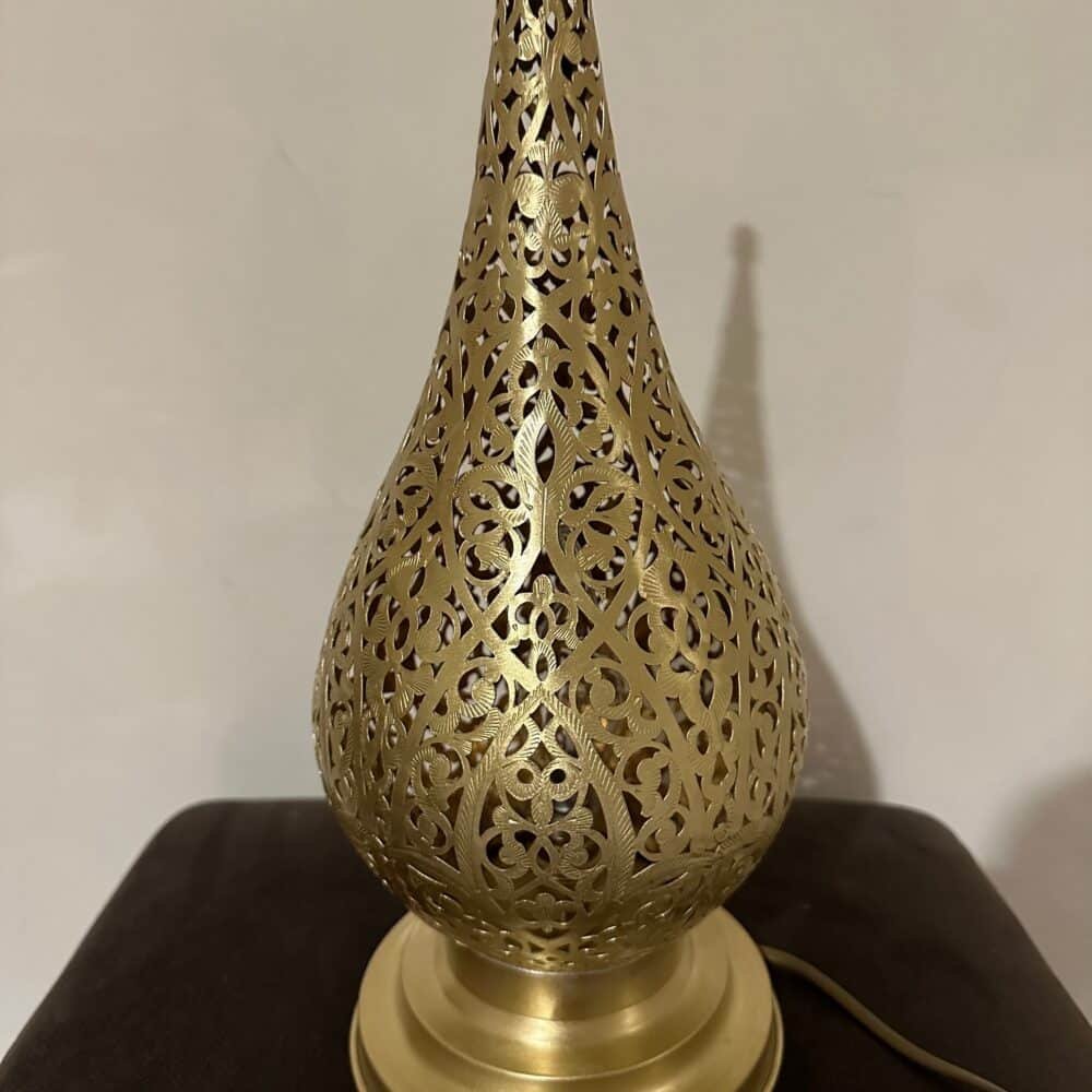 Elegant gold table lamp on a bedside table in a cozy bedroom.