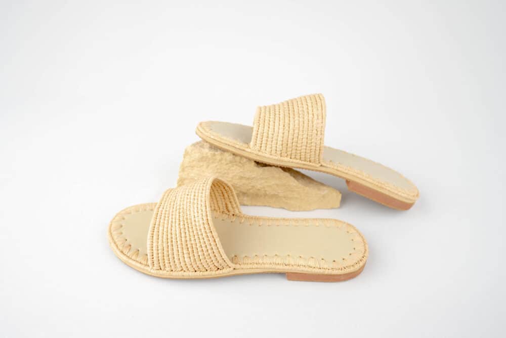 Person wearing Astonishing Seagrass Raffia Sandals walking outdoors on a sunny day.