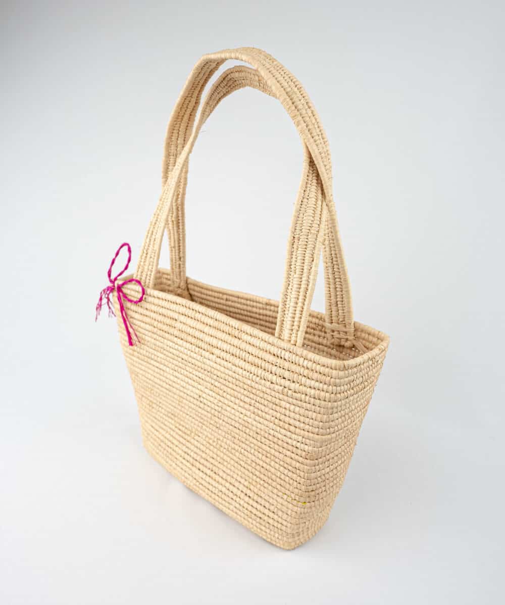 Brilliant Raffia Beach Bag on the beach with sunglasses and towels inside