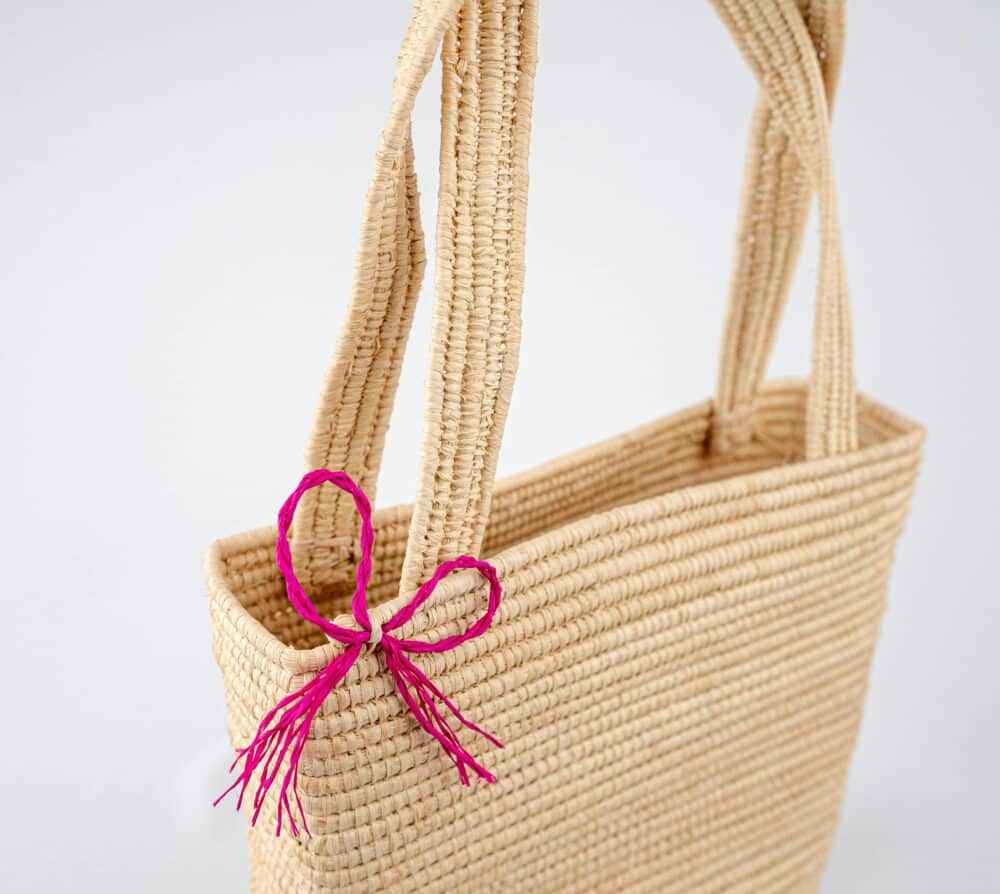 Lifestyle shot of the Brilliant Raffia Beach Bag paired with a summer outfit