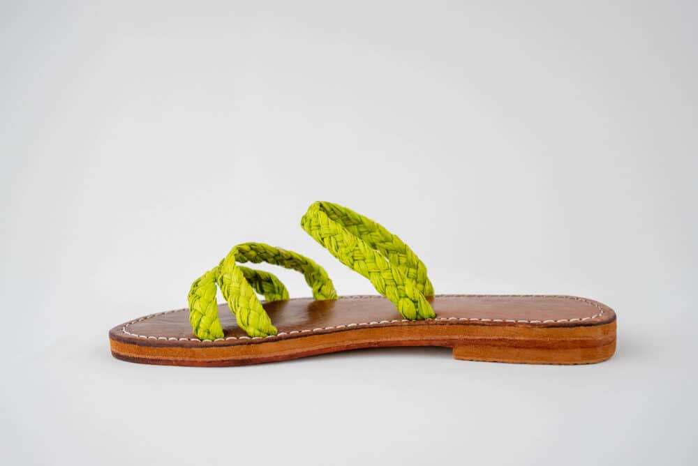 Person wearing Adorable Summer Slide Raffia Shoes on a beach, walking comfortably in the summer sun