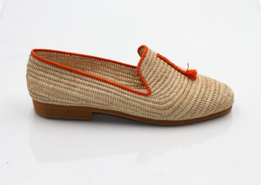Close-up of the creamy raffia weave and vibrant orange accents on the shoes