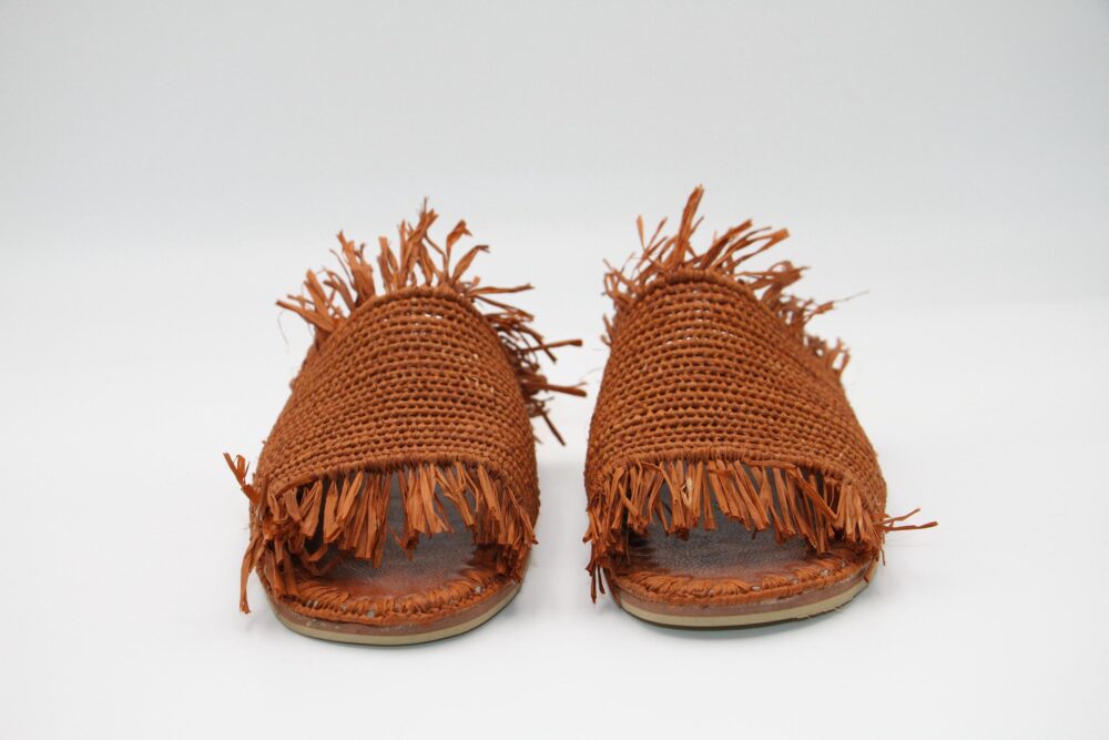 Close-up of the caramel raffia texture on sandals